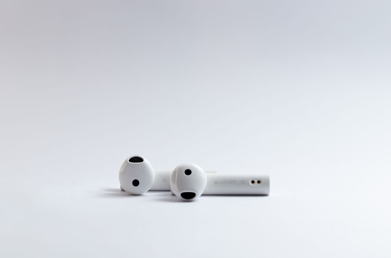 about-02 Close-up of white wireless earphones on a clean white background, ideal for tech and lifestyle concepts.